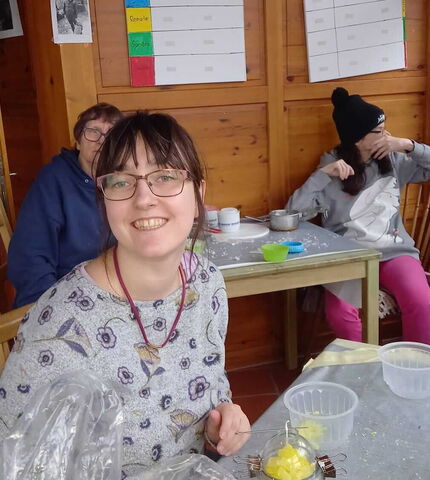 Eine Bewohnerin der Wohngemeinschaft St. Martin stellt Kerzen her.