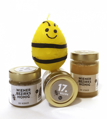 Eine lustige Kerze, die ausschaut wie eine Biene, aus der Kerzenwerkstatt der Wohngemeinschaft St. Martin in Klosterneuburg mit drei Gläsern Honig von Wiener Bezirks Honig.