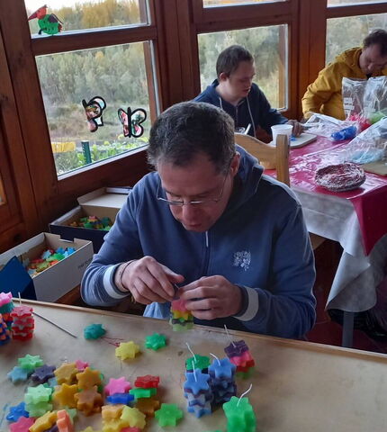 Ein Bewohner der Wohngemeinschaft St. Martin bastelt Kerzen in Sternenform.