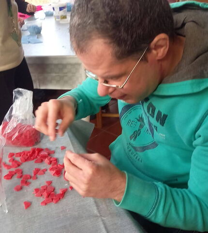 Ein Bewohner der Wohngemeinschaft St. Martin stellt eine Kerze her.