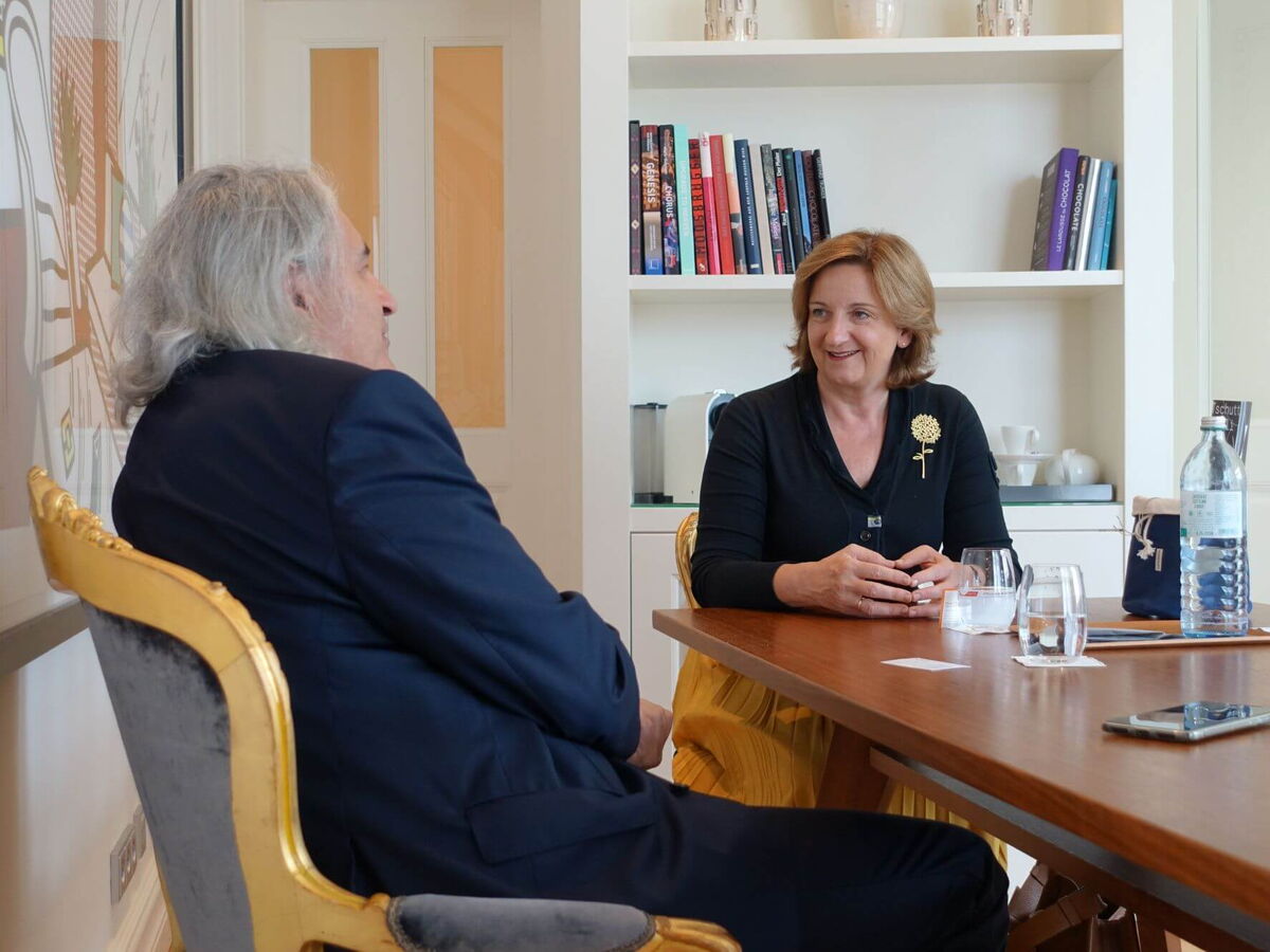 Andrea Fuchs und Thomas Rihl im Gespräch an einem Tisch in einem der schönsten Zimmer im Hotel Sans Souci Wien.