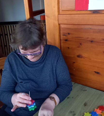 Eine Bewohnerin der Wohngemeinschaft St. Martin bastelt Kerzen in Sternenform.