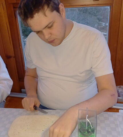 Ein Bewohner der Wohngemeinschaft St. Martin bastelt eine Kerze.