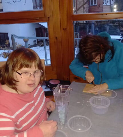 Eine Bewohnerin der Wohngemeinschaft St. Martin stellt Kerzen her.