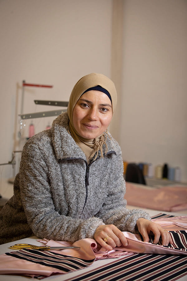 Rania Baghdadi in der Näherei mit Stoffen.