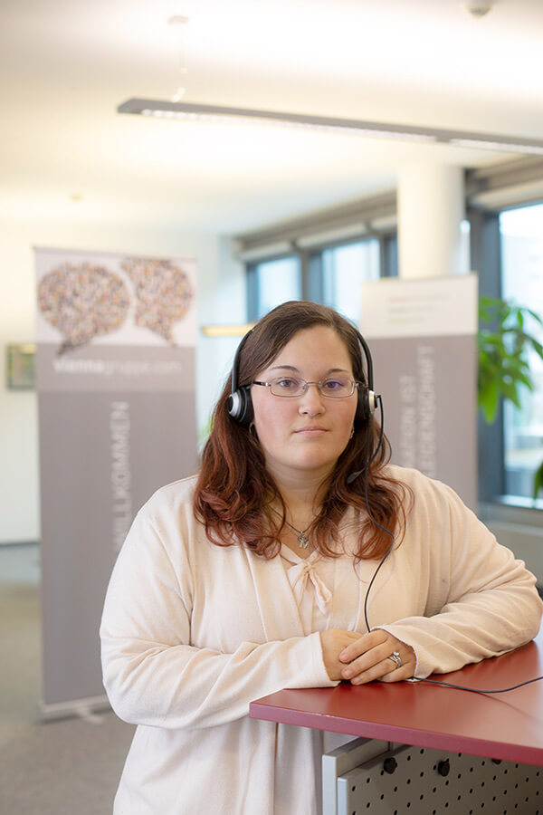 Natascha Zidek im Büro mit Headset.