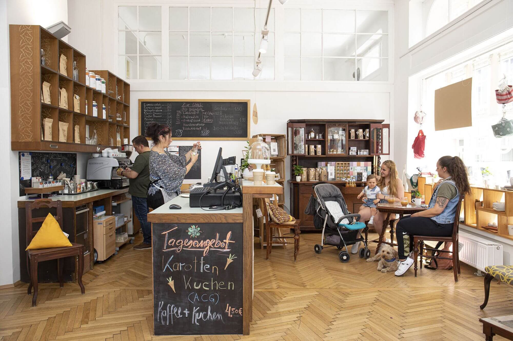 Gäste sitzen in unserem Social Concept Store Schön und Gut an einem Tisch und genießen Getränke.