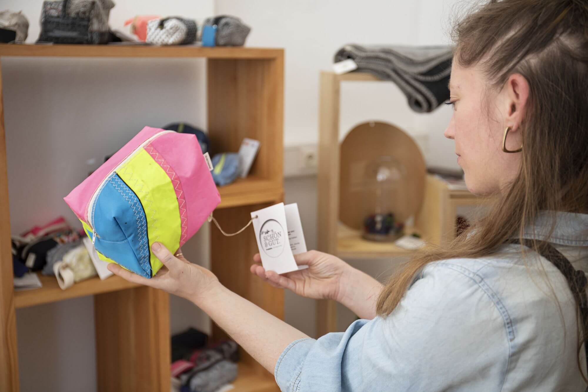 Verkäuferin zeigt einen upgecycelten Stoffbeutel in unserem Social Concept Store Schön und Gut.