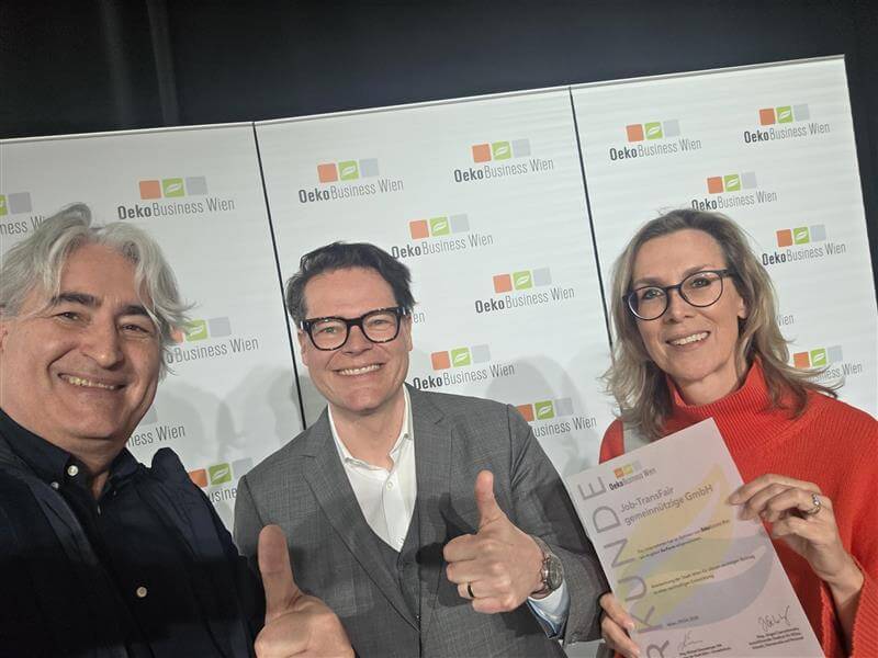 Selfie mit drei Personen, eine davon hält eine Urkunde in der Hand.